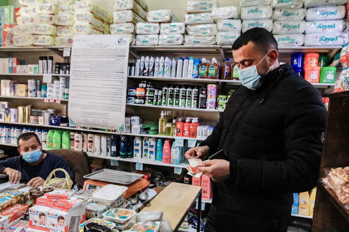 Leen’s father, Mohamed. using cash assistance to buy groceries for the family. Photo by Mohammed Al Reefi for the Catholic Relief Services.