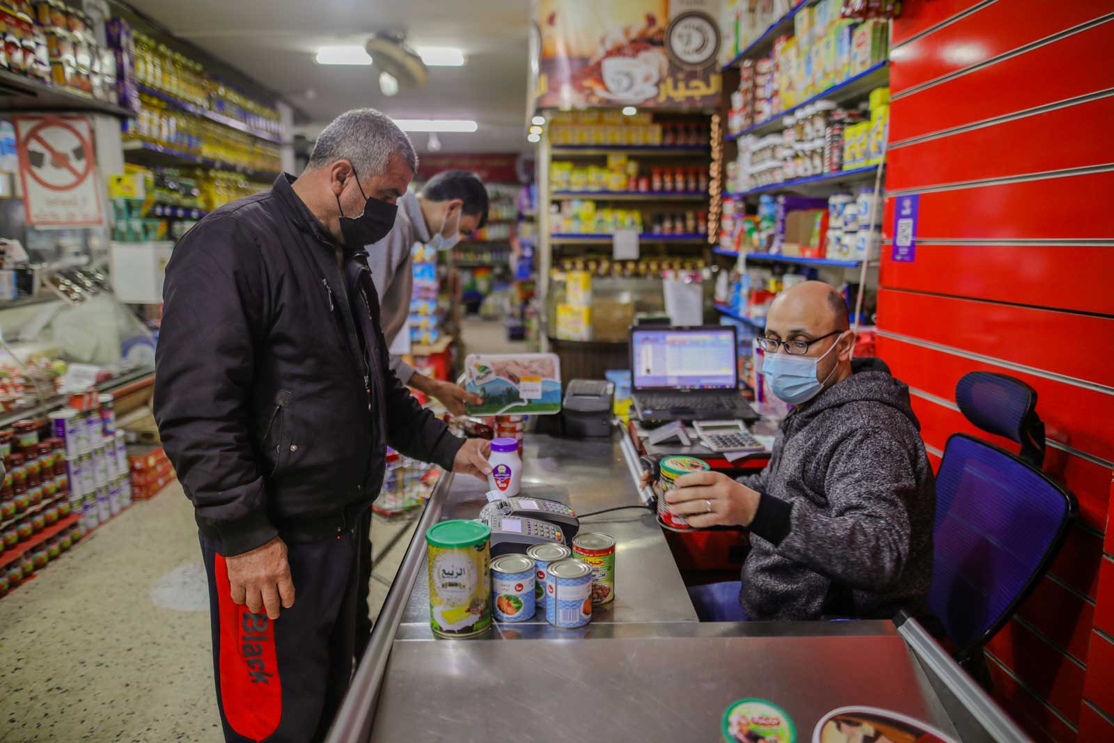 Using an e-voucher, Mohammed selects food and living supplies for his family. Photo by Mohamed Reefi for CRS