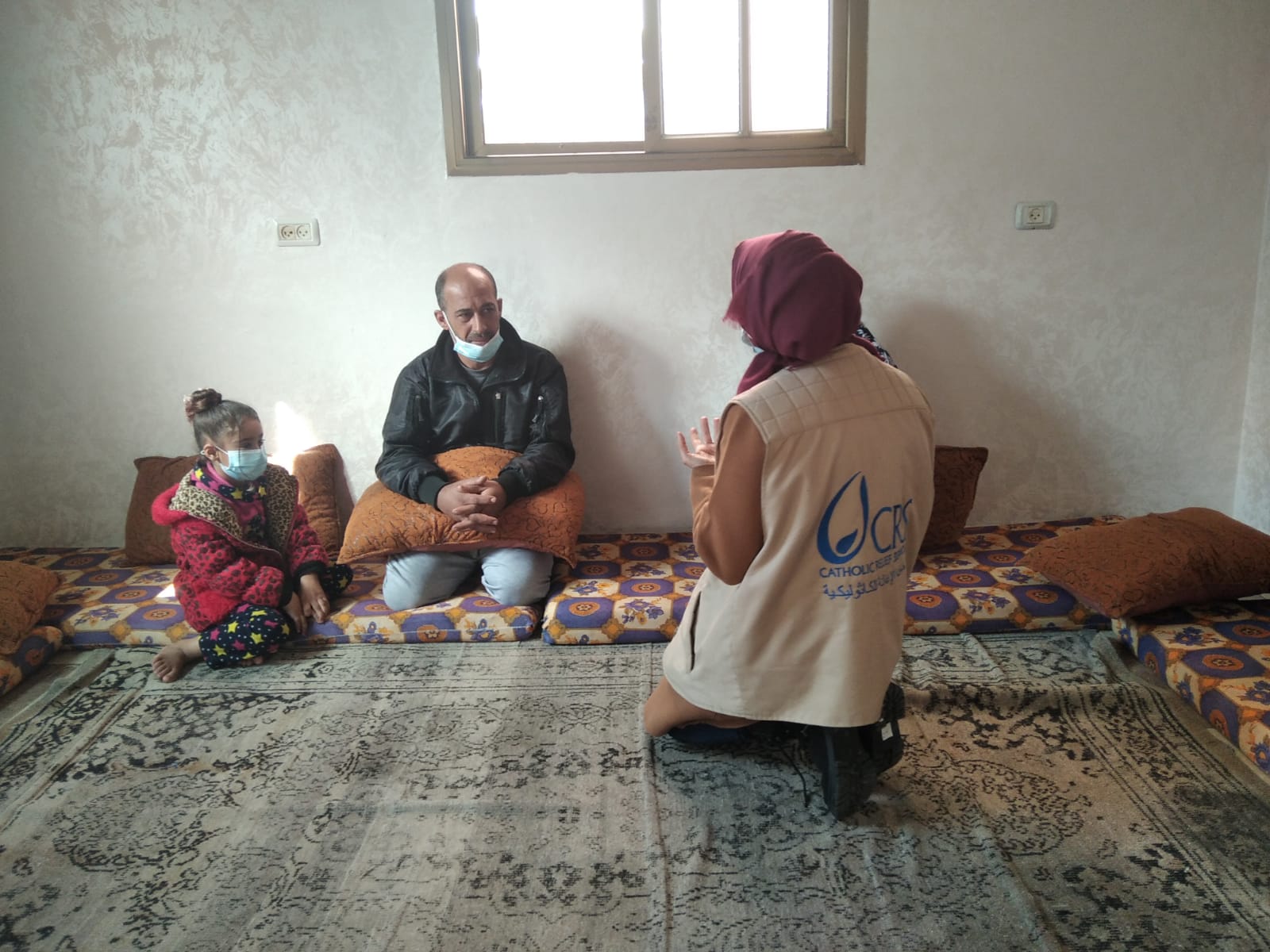 Sade and a Catholic Relief Services staff member discussing the renovation works in the presence of one of Sade and Asmaa’s daughters.