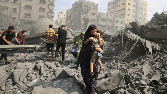 Palestinians in Gaza city inspect the damage following an Israeli airstrike, 9 October 2023, photo by Mahmud HAMS / AFP
