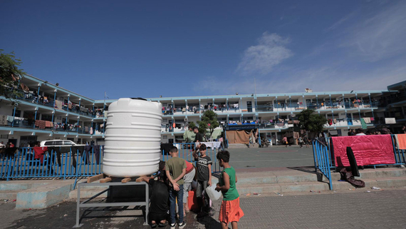 Displaced children queueing for water in a UN shelter in Gaza. Photo by UNRWA 