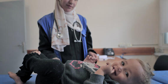 May 26, 2024, Rafah: A staff member from the UNRWA Health Team at the Tel Al-Sultan Health Center in Rafah area conducts a medical examination for a displaced child.© 2024 UNRWA Photo by Mohammed Hinnawi