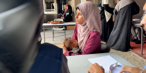 إيمان، البالغة من العمر سبعة أشهر، مع والدتها في نقطة طبية بمدرسة جرى تحويلها إلى مركز إيواء بمدينة غزة. وقد شُخصت إصابتها بسوء التغذية الحاد الوخيم عندما كانت في الشهر السادس من عمرها، وتقدم الفرق الصحية التابعة لوكالة الأونروا العلاج الطارئ لها إلى جانب الأغذية التكميلية. تصوير وكالة الأونروا، جميع الحقوق محفوظة، 2025