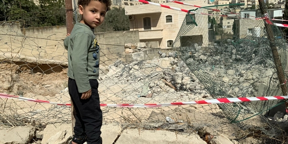 فتى فلسطيني مهجر بجوار ما تبقّى من منزله الذي أجبرت السلطات الإسرائيلية والديه على هدمه في 20 تشرين الأول/أكتوبر في الطور بالقدس الشرقية. تصوير: مكتب الأمم المتحدة لتنسيق الشؤون الإنسانية