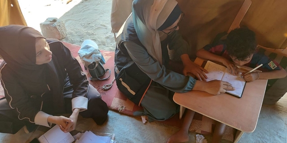 Eight-year-old Ibrahim while using his customized slant board to study, September 2025. Photo by EducAid