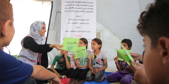 AWDA team member providing psychosocial support to children in Gaza, 2023. Photo by AWDA. (Sara and her children are not pictured.)
