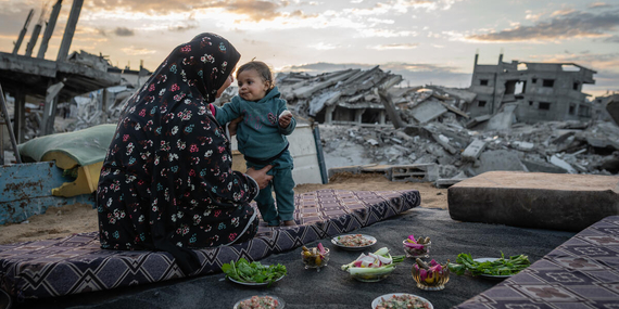 Um Omar, a Palestinian from Gaza, breaking the Ramadan fast out in the open, surrounded by debris. Photo by WFP