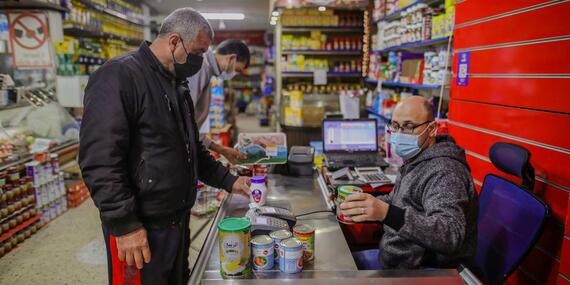 Using an e-voucher, Mohammed selects food and living supplies for his family. Photo by Mohamed Reefi for CRS