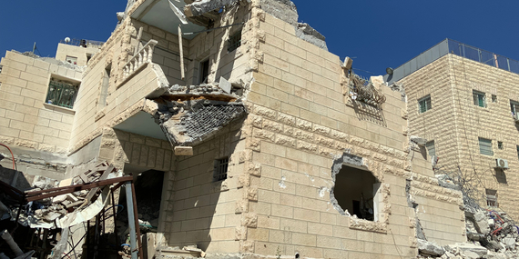 بناية سكنية تتألف من ستة طوابق، أُجبر مالكها الفلسطيني على هدمها بحجة افتقارها إلى رخص البناء التي تصدرها السلطات الإسرائيلية، والتي يُعد الحصول عليها من ضرب المستحيل. ونتيجة لذلك تعرّضت أسرة تضم 29 فردًا للنزوح. جبل المكبر، القدس الشرقية. تصوير مكتب الأمم المتحدة لتنسيق الشؤون الإنسانية