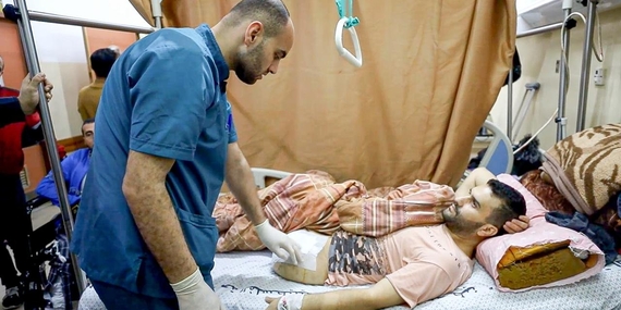 A medical team member attending the wounds of a Palestinian in Gaza. Photo by the World Health Organization