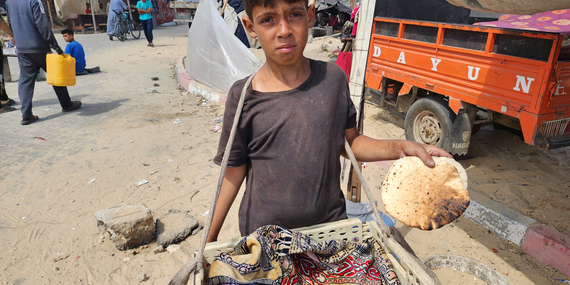 يوسف (13 عامًا) يحمل رغيفًا من الخبز إلى أسرته في المواصي. تصوير اليونيسف