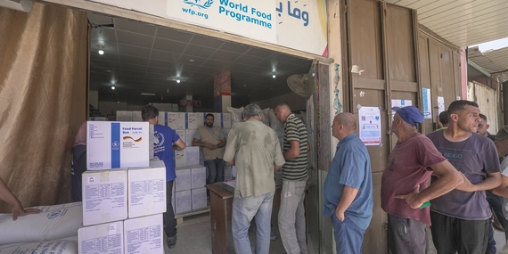 أشخاص يصطفون في طابور لتلقي المعونات الغذائية في غزة. تصوير برنامج الأغذية العالمي