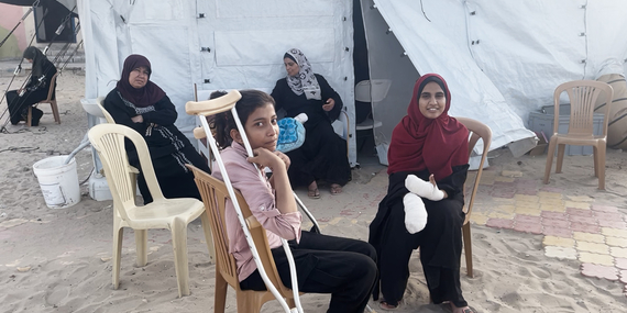فتيات يجلسن في مستشفى ميداني تابع للهيئة الطبية الدولية بعد أن تلقين العلاج الطبي لإصابات لحقت بهن خلال غارة جوية على موقع للنازحين في رفح في 26 أيار/مايو. تصوير مكتب الأمم المتحدة لتنسيق الشؤون الإنسانية/ياسمينة غيردا، 27 أيار/مايو 2024