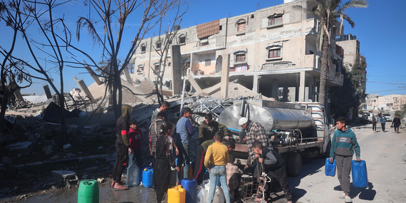 ילדים מתאספים סביב מכליות מים ברפיח. צילום: יוניסף / אל-באבא