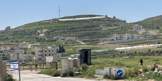 فلسطيني يسير بجانب بوابة حديدية مغلقة نصبتها القوات الإسرائيلية لإغلاق طريق يؤدي إلى مخيم الفوار جنوب الضفة الغربية. تصوير مكتب الأمم المتحدة لتنسيق الشؤون الإنسانية
