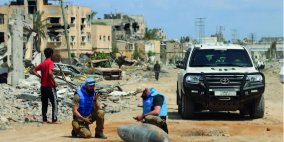 A UN team inspects an unexploded 1,000-pound bomb lying on a main road in Khan Younis. Photo: OCHA/Themba Linden.