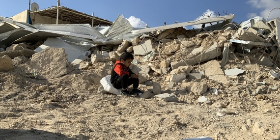 A Palestinian child sitting on the rubble of his families demolished house in Jabal Al Mukkabir, East Jerusalem. Photo by OCHA