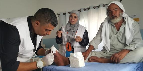 Nabil Al Amour (on the right) receiving care in a mobile clinic. Photo by Anees Mahareeq @CARE 2021