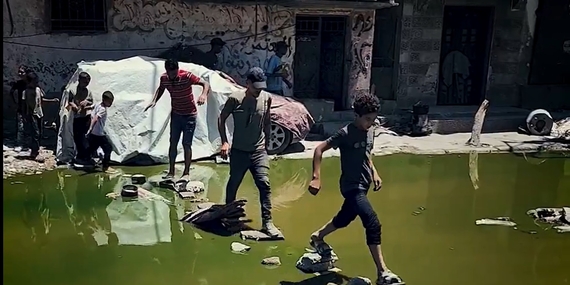 أطفال يتنقلون في شارع تغمره مياه الصرف الصحي في غزة. تصوير اليونيسف