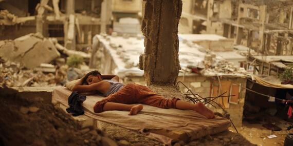 Palestinian boy sleeping inside his destroyed home in the Shuja’iyeh neighbourhood of Gaza City, September 2015. Photo by Suhaib Salem