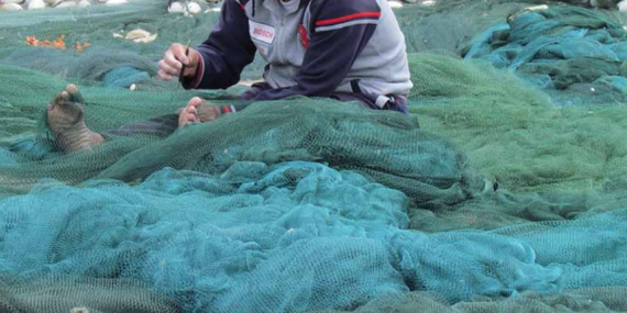 Gaza fisherman working on his nets Gaza fishing wharf. Gaza city, April 2013. Photo by OCHA