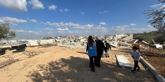 أسرة فلسطينية من دير بلوط، سلفيت، تُطْلِع عاملة في مجال تقديم المعونات على المباني الزراعية الثلاثة التي هدمتها الإدارة المدنية الإسرائيلية، 17 كانون الأول/ديسمبر 2024. تصوير مكتب الأمم المتحدة لتنسيق الشؤون الإنسانية