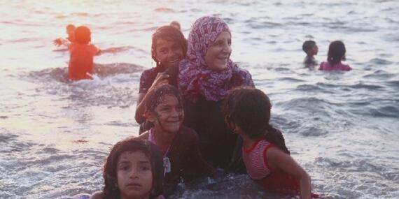 Ahlam joining her children in swimming at the beach.  Dear Al Balah Camp. © Photo Credit: Rehaf Batniji/OXFAM 2018