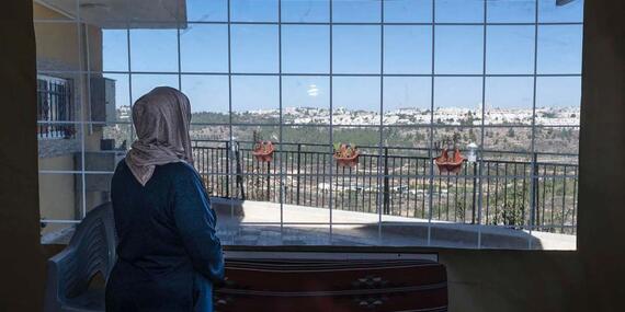 Nadia As Seifi looking out her window in Al Walaja (Bethlehem); her home is at risk of being demolished by the Israeli authorities.