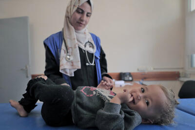 May 26, 2024, Rafah: A staff member from the UNRWA Health Team at the Tel Al-Sultan Health Center in Rafah area conducts a medical examination for a displaced child.© 2024 UNRWA Photo by Mohammed Hinnawi