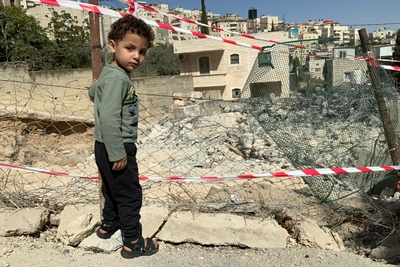 فتى فلسطيني مهجر بجوار ما تبقّى من منزله الذي أجبرت السلطات الإسرائيلية والديه على هدمه في 20 تشرين الأول/أكتوبر في الطور بالقدس الشرقية. تصوير: مكتب الأمم المتحدة لتنسيق الشؤون الإنسانية