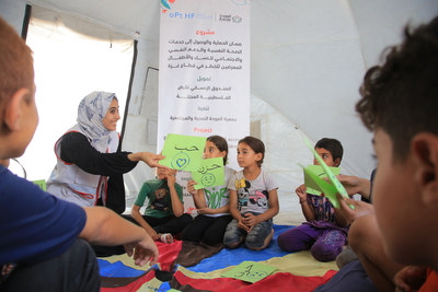 AWDA team member providing psychosocial support to children in Gaza, 2023. Photo by AWDA. (Sara and her children are not pictured.)