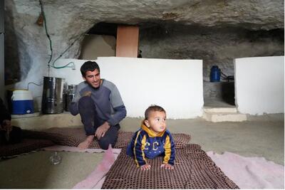 Mohammed and his baby at home. Photo: Ma'an