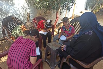 Ghada and her children sitting on the newly bought plastic chairs, September 2020. Photo by SIF