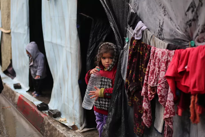 طفلان نازحان أمام مسكنيهما المؤقتين في غزة. تصوير اليونيسف/البابا