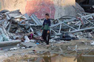 فتى يمر بجانب حفرة ناجمة عن انفجار قرب مستشفى كمال عدوان. تصوير مكتب الأمم المتحدة لتنسيق الشؤون الإنسانية/ثيمبا ليندن
