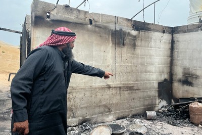 أحد سكان قرية بردلة الفلسطينية يشير إلى منزله الذي أحرقه المستوطنون الإسرائيليون، حيث أدّى الحريق المتعمد إلى تدمير المنازل وحظائر الحيوانات، مما أسفر عن تهجير أسرتين وتقويض سبل عيشهم. تصوير مكتب الأمم المتحدة لتنسيق الشؤون الإنسانية.