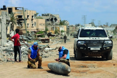 A UN team inspects an unexploded 1,000-pound bomb lying on a main road in Khan Younis. Photo: OCHA/Themba Linden.