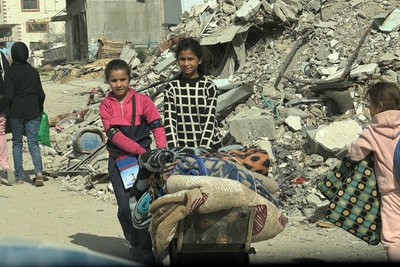 Girls carrying winter assistance items provided to them in Gaza city, 13 March 2025. Photo by OCHA/Olga Cherevko