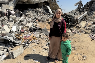 Yasmeen and her son stand amid the rubble of their destroyed home in Gaza, where renewed airstrikes and aid restrictions have deepened the humanitarian crisis. Photo: OCHA/Olga Cherevko
