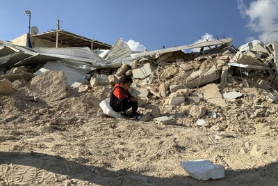 A Palestinian child sitting on the rubble of his families demolished house in Jabal Al Mukkabir, East Jerusalem. Photo by OCHA