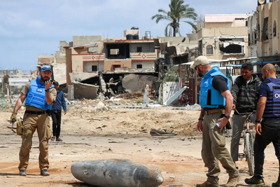 فريق أممي يفحص قنبلة غير متفجرة يبلغ وزنها 1000 رطلا (حوالي 455 كغم)، وهي ملقاة على الشارع الرئيسي في خان يونس. تصوير: مكتب الأمم المتحدة لتنسيق الشؤون الإنسانية/ثمبا ليندن