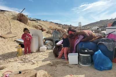 ילדים על רקע חפצים שהוצאו מבית פלסטיני שכוחות ישראליים עמדו להרוס בתל אל-ח׳שבה, נפת שכם. צילום: משרד האו״ם לתיאום עניינים הומניטריים, 10 בדצמבר 2024