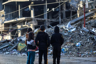 أطفال يقفون أمام منزل هُدم بسبب القصف في مدينة رفح، جنوب قطاع غزة. تصوير: اليونيسف/إياد البابا