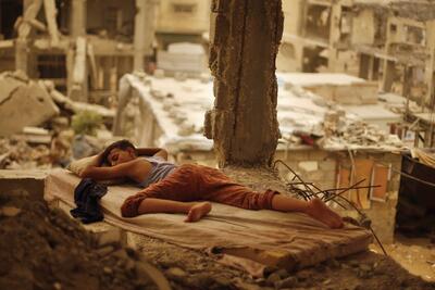 Palestinian boy sleeping inside his destroyed home in the Shuja’iyeh neighbourhood of Gaza City, September 2015. Photo by Suhaib Salem