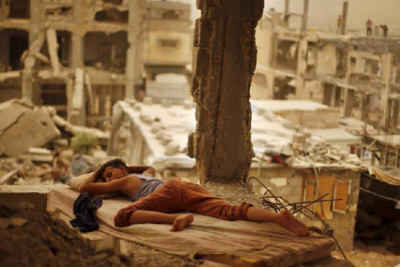 Palestinian boy sleeping inside his destroyed home in the Shuja’iyeh neighbourhood of Gaza City, September 2015. Photo by Suhaib Salem/
