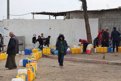 تجهيز الصفائح لتعبئتها بالمياه. لا يعمل سوى خط واحد من الخطوط الثلاثة التي تورد المياه من إسرائيل بسبب الأضرار التي لحقت بخط أنابيب في الآونة الأخيرة وهو في حاجة ماسة إلى التصليحات. وقد حذّرت اليونيسف من أن الأطفال في جنوب غزة لا يحصلون إلا على 1.5 إلى 2 لتر من الماء يوميًا، وهو أقل بكثير من المتطلبات الموصى بها للبقاء على قيد الحياة. تصوير اليونيسف/إياد البابا، 11 كانون الثاني/يناير