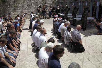 فلسطينيون يصلون خارج الحرم القدسي الشريف/جبل الهيكل احتجاجا على أجهزة كشف المعادن التي تم تركيبها حديثا، البلدة القديمة في القدس، 16 تموز/يوليو 2017. تصوير محمود اللين