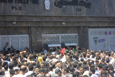 People queuing at the ATM at the Bank of Palestine. Rimal area, Gaza. January 2015. Photo by OCHA